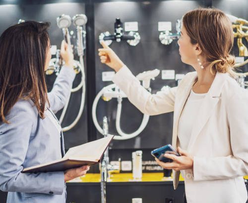Businesswoman owning small business store. She is talking with a customer who is choosing the goods.