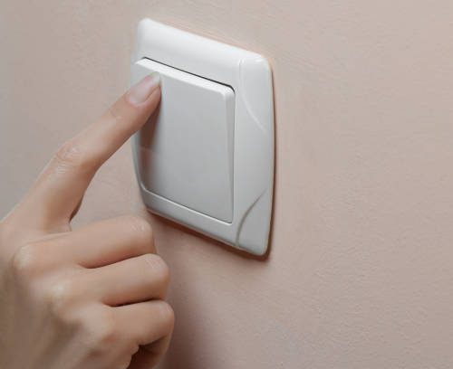 The concept of saving electricity. The girl turns off the lights in the room. close-up