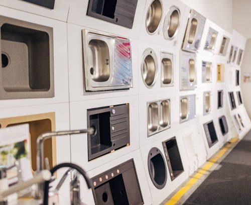 Sinks of different shapes and colors displayed in the department store, in the section with household appliances