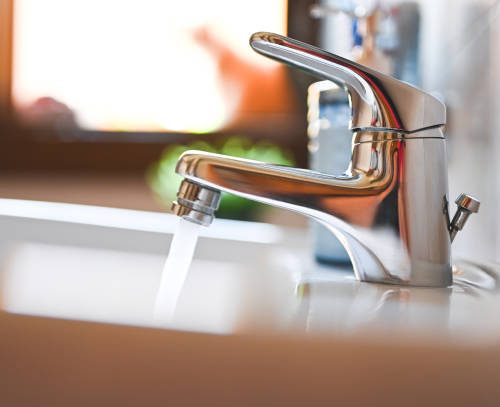 Window sink with cat and  Water pouring from sink faucet
