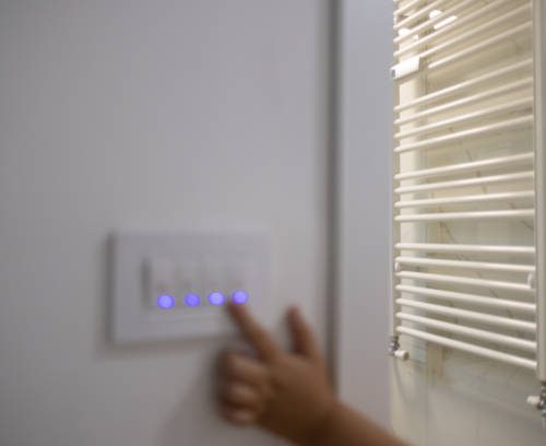Unrecognizable person turning lights off with her finger on a light switch