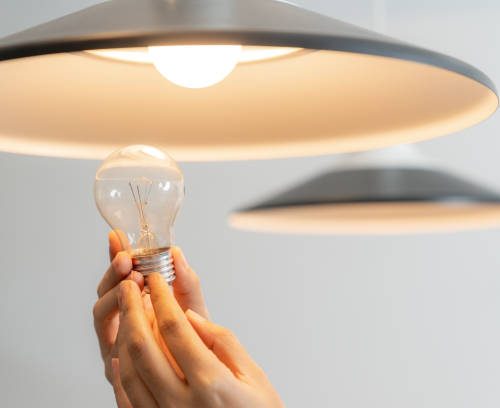 The young woman is changing light bulbs at home